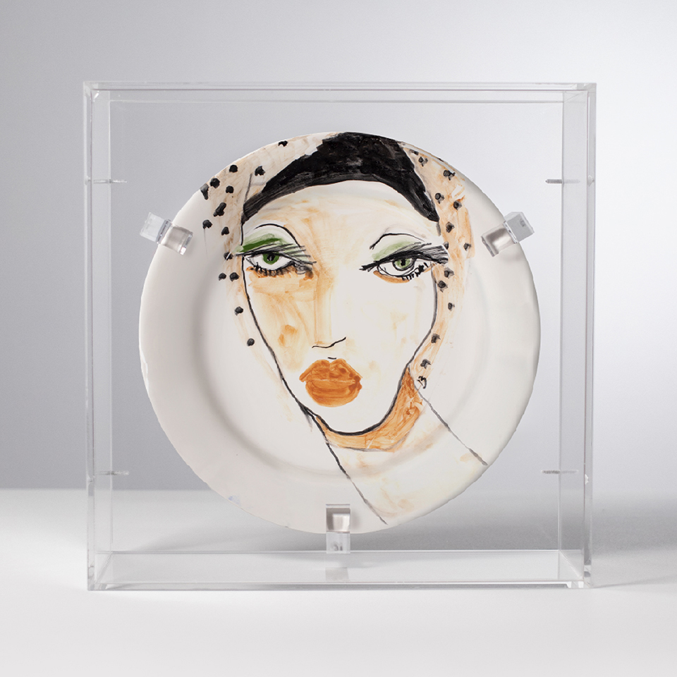 Piatto in ceramica illustrato esposto in teca trasparente