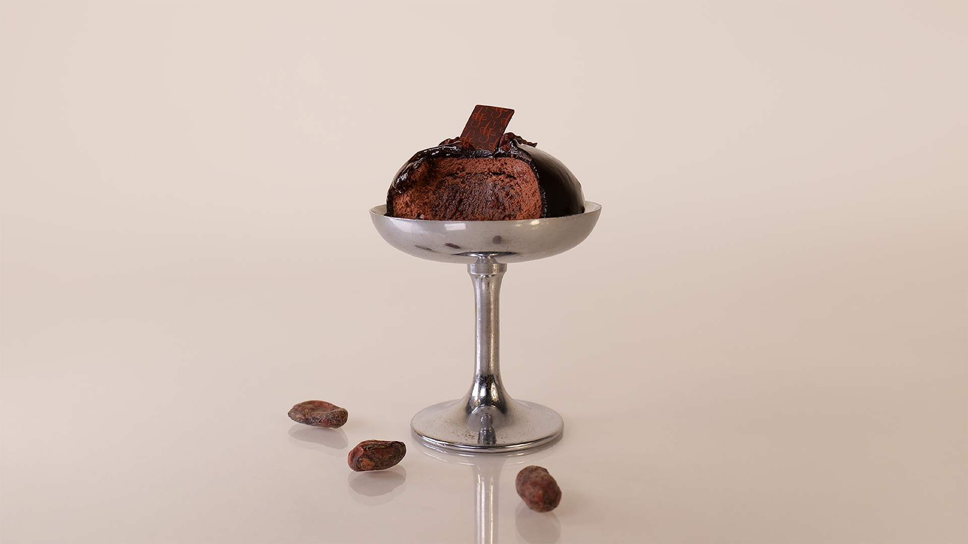 Monoporzione al cioccolato fondente con fave di cacao, luce controllata e styling essenziale