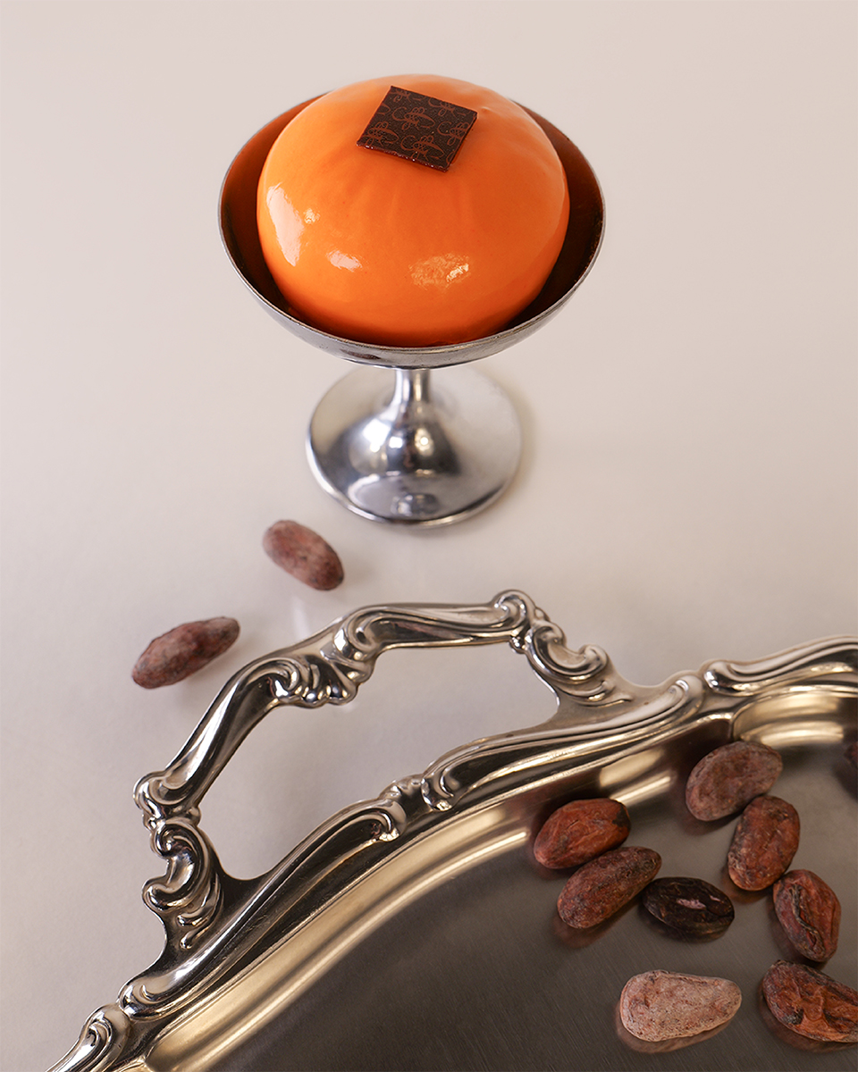 Monoporzione dal design scultoreo, glassa lucida e resa materica del prodotto e fave di cacao