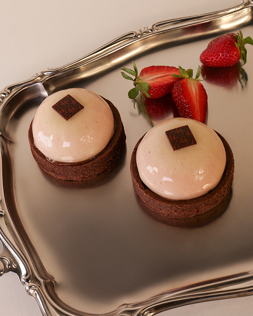 Dolci monoporzione al cioccolato con fragole, styling elegante su vassoio riflettente vista mobile