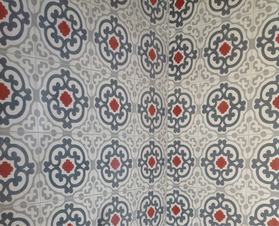 Dettaglio delle piastrelle decorative grigie con motivi geometrici e piccoli accenti rossi utilizzate nel progetto A Bastidon in Saint-Tropez