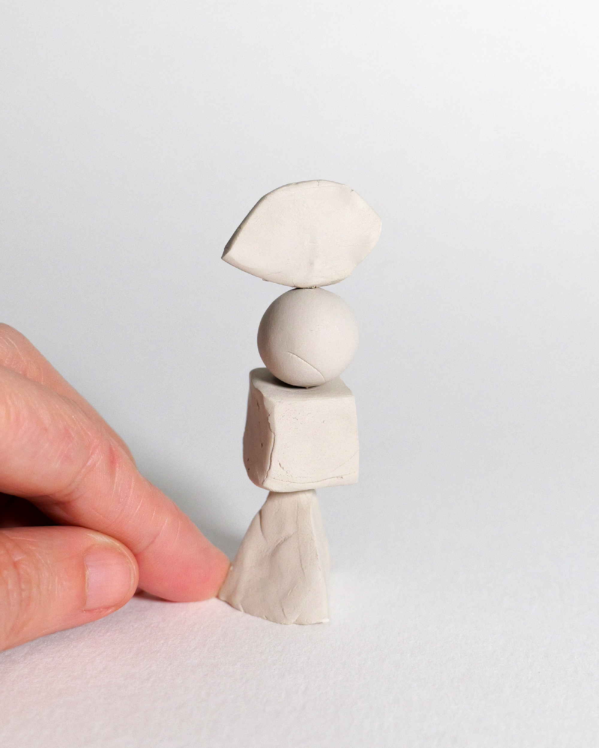 Mano che mostra la piccola scultura in argilla realizzata come manifesto visivo del convegno Salute e Sicurezza sul Lavoro.